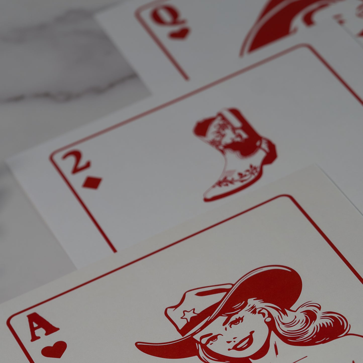 Western wall art poster featuring a 5-piece art set with red illustrations of playing cards on a white background, including cowgirl, boot, queen of hearts, cherries, and horseshoe designs