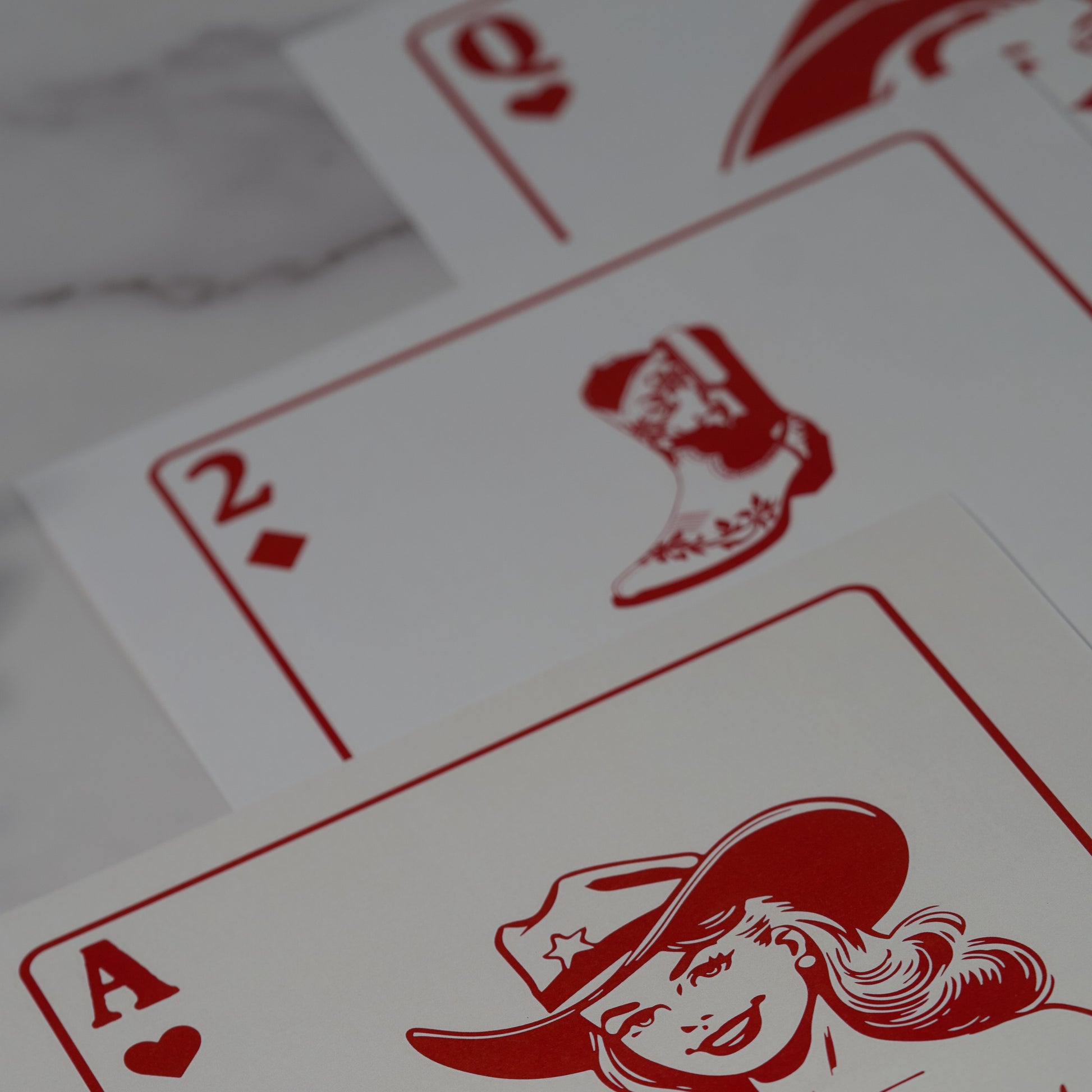 Western wall art poster featuring a 5-piece art set with red illustrations of playing cards on a white background, including cowgirl, boot, queen of hearts, cherries, and horseshoe designs