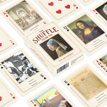 Flat lay of Shuffle Club Co. Fine Art Edition deck, showing the cream-colored box and playing cards scattered around, each card featuring iconic artworks such as the Mona Lisa, School of Athens, Guernica, and other masterpieces.